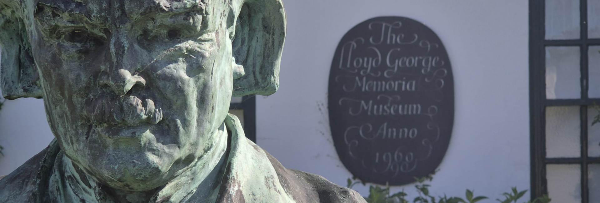 Photo with a bronze statue of Lloyd George in the foreground and museum in the background